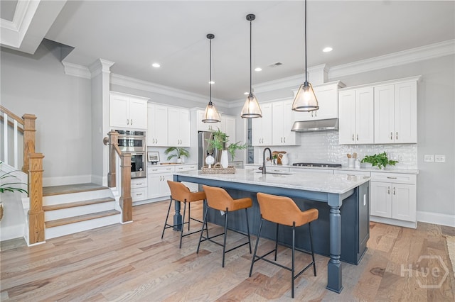 122 Kent, Pooler, GA 31322 - kitchen with under cabinet range hood, stainless steel appliances, light wood-type flooring, a breakfast bar, and decorative backsplash