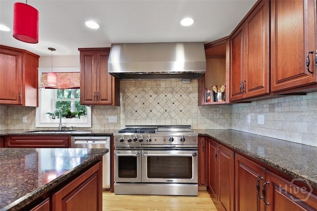 606 Rivers End Dr, Savannah, GA 31406 - kitchen with wall chimney range hood, appliances with stainless steel finishes, dark stone counters, decorative backsplash, and hanging light fixtures