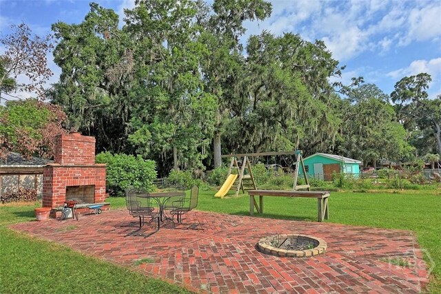 606 Rivers End Dr, Savannah, GA 31406 - view of patio featuring a playground, an outdoor brick fireplace, and view of scattered trees