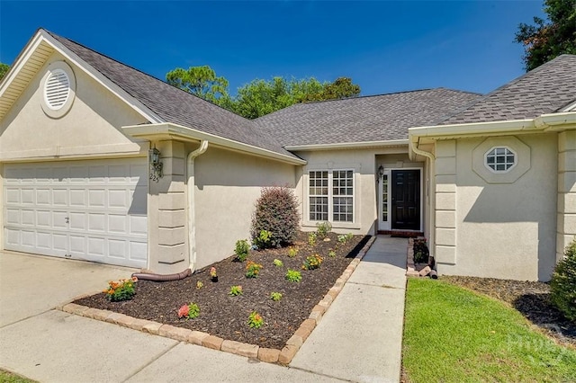 225 Jasper Ln, Rincon, GA 31326 - doorway to property featuring stucco siding, roof with shingles, concrete driveway, and an attached garage