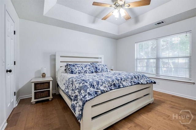 225 Jasper Ln, Rincon, GA 31326 - bedroom featuring a tray ceiling, wood finished floors, and a ceiling fan