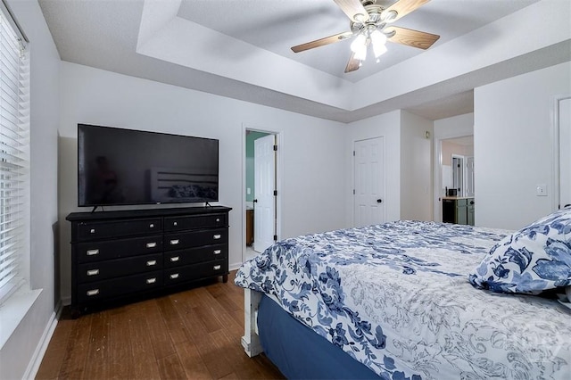 225 Jasper Ln, Rincon, GA 31326 - bedroom with dark wood-style floors, a tray ceiling, and a ceiling fan