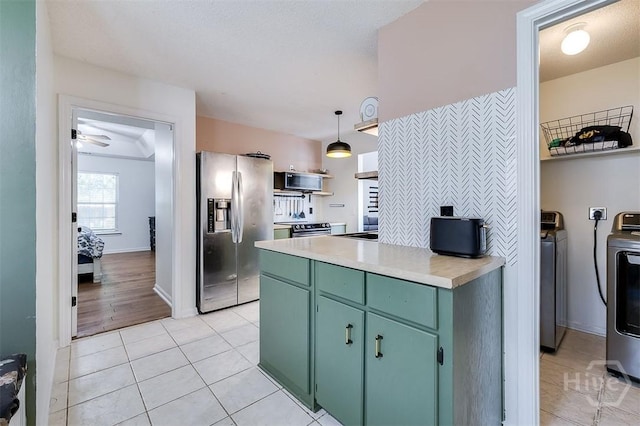 225 Jasper Ln, Rincon, GA 31326 - kitchen with stainless steel appliances, green cabinetry, separate washer and dryer, light countertops, and light tile patterned floors