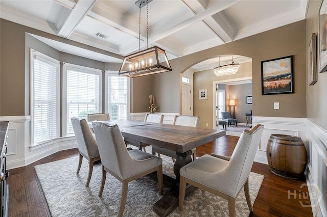 121 Cypress Loop, Bloomingdale, GA 31302 - dining space featuring arched walkways, a chandelier, coffered ceiling, beam ceiling, and a wainscoted wall