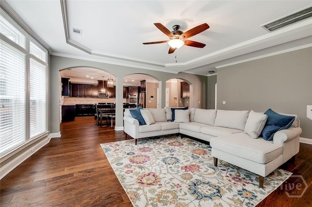 121 Cypress Loop, Bloomingdale, GA 31302 - living room with a raised ceiling, arched walkways, a ceiling fan, dark wood finished floors, and ornamental molding