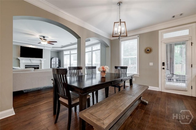 121 Cypress Loop, Bloomingdale, GA 31302 - dining area with dark wood-type flooring, crown molding, arched walkways, ceiling fan, and a chandelier