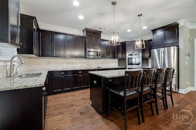 121 Cypress Loop, Bloomingdale, GA 31302 - kitchen with stainless steel appliances, a kitchen island, crown molding, light stone countertops, and dark wood-type flooring