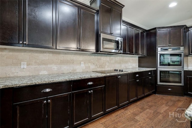 121 Cypress Loop, Bloomingdale, GA 31302 - kitchen featuring stainless steel appliances, dark wood-style floors, light stone countertops, decorative backsplash, and crown molding