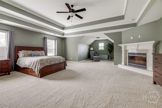 121 Cypress Loop, Bloomingdale, GA 31302 - bedroom featuring a tray ceiling, carpet, ceiling fan, and a glass covered fireplace