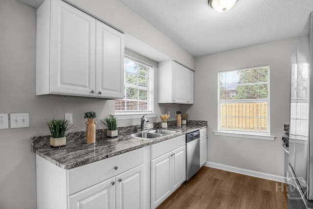 213 Executive Park Dr, Savannah, GA 31406 - kitchen featuring stainless steel dishwasher, dark wood finished floors, white cabinets, and a textured ceiling