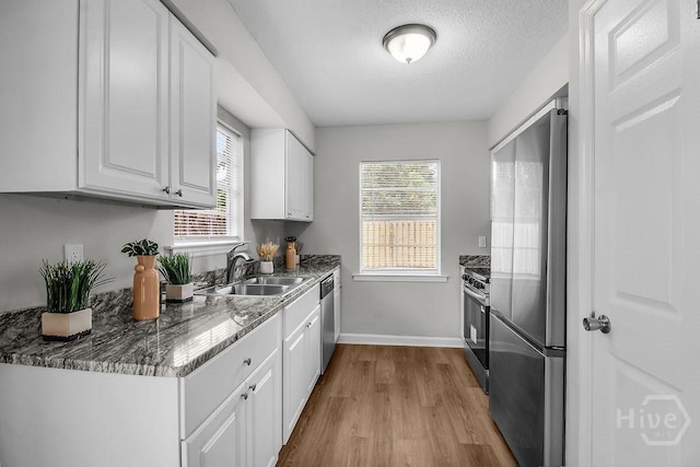 213 Executive Park Dr, Savannah, GA 31406 - kitchen with stainless steel appliances, white cabinetry, wood finished floors, healthy amount of natural light, and a textured ceiling