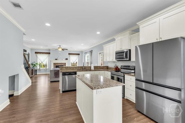 291 Kerry Dr, Richmond Hill, GA 31324 - kitchen featuring appliances with stainless steel finishes, plenty of natural light, ceiling fan, crown molding, and a kitchen island