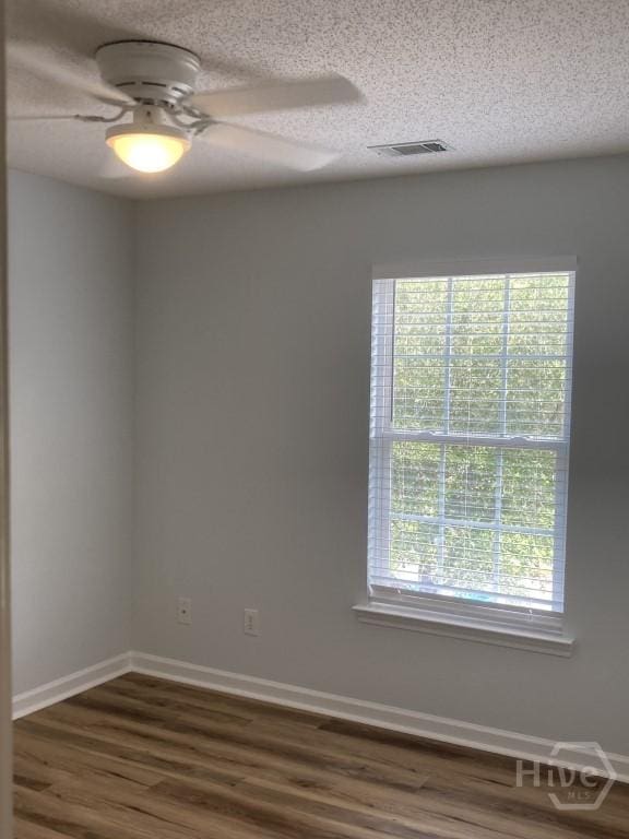 129 Ridgewood Cir, Rincon, GA 31326 - empty room with dark wood finished floors, ceiling fan, and a textured ceiling