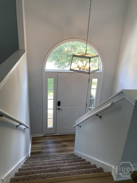 129 Ridgewood Cir, Rincon, GA 31326 - foyer entrance featuring stairs, a chandelier, dark wood finished floors, and a towering ceiling