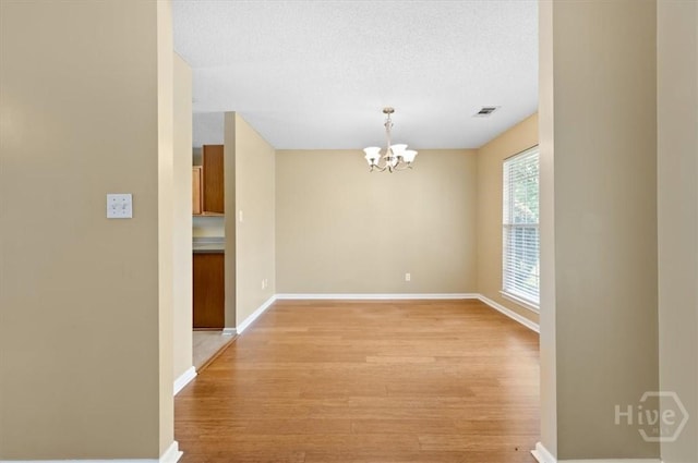 10 Cassidy Ct, Pooler, GA 31322 - spare room featuring light wood-style flooring, a chandelier, and a textured ceiling