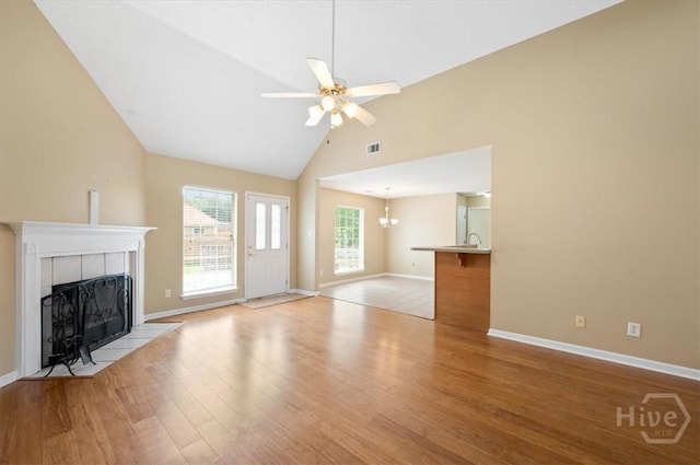 10 Cassidy Ct, Pooler, GA 31322 - unfurnished living room with a tile fireplace, light wood finished floors, a ceiling fan, a chandelier, and high vaulted ceiling