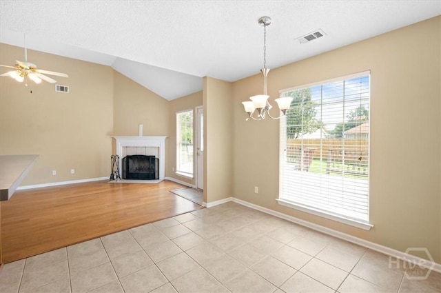 10 Cassidy Ct, Pooler, GA 31322 - unfurnished living room with plenty of natural light, light tile patterned floors, a chandelier, a tiled fireplace, and lofted ceiling