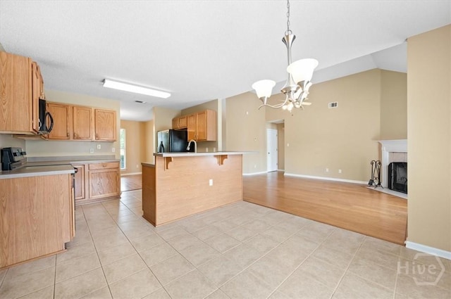 10 Cassidy Ct, Pooler, GA 31322 - kitchen with freestanding refrigerator, a chandelier, light tile patterned floors, a kitchen bar, and black microwave