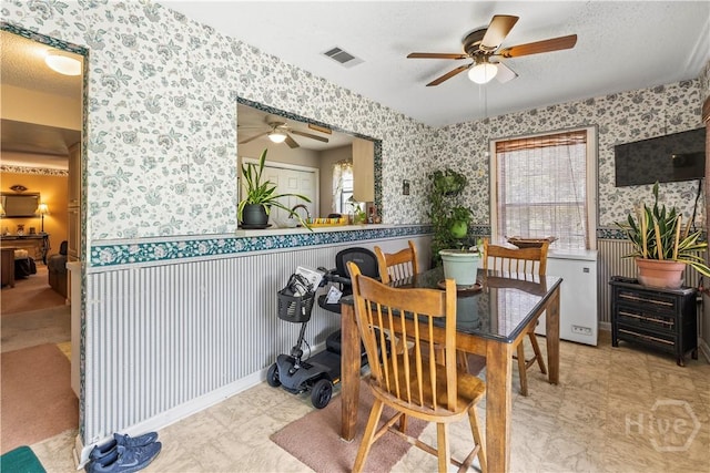 675 Foxwood Cir, Jesup, GA 31545 - dining space featuring wallpapered walls, ceiling fan, a wainscoted wall, and plenty of natural light
