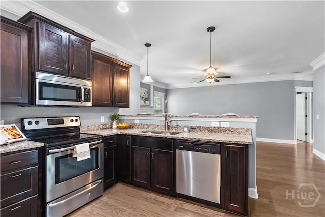 85 Wicklow Dr, Richmond Hill, GA 31324 - kitchen with stainless steel appliances, a peninsula, ceiling fan, ornamental molding, and dark brown cabinetry