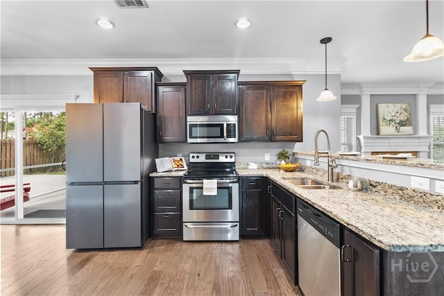 85 Wicklow Dr, Richmond Hill, GA 31324 - kitchen featuring stainless steel appliances, ornamental molding, a peninsula, wood finished floors, and light stone countertops