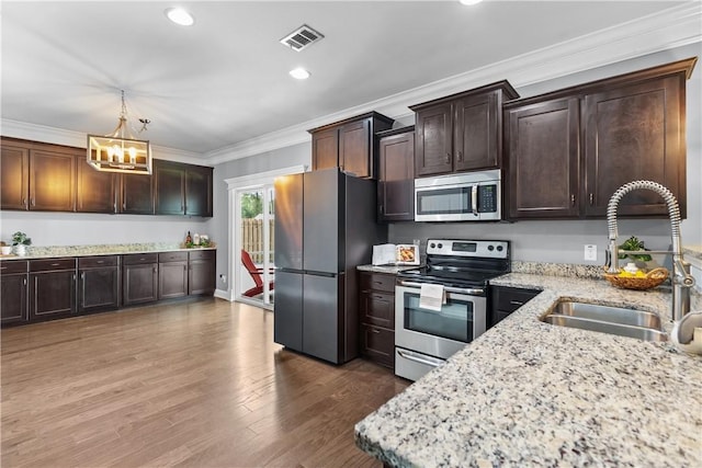 85 Wicklow Dr, Richmond Hill, GA 31324 - kitchen with stainless steel appliances, a chandelier, crown molding, light stone countertops, and dark brown cabinetry