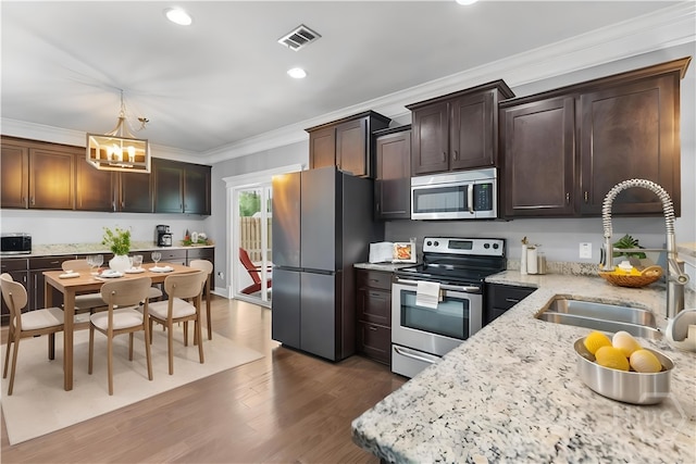 85 Wicklow Dr, Richmond Hill, GA 31324 - kitchen featuring stainless steel appliances, a chandelier, crown molding, dark brown cabinets, and dark wood-style flooring