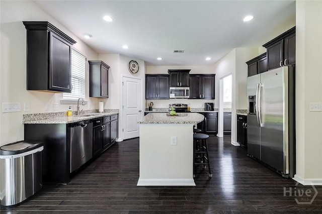 353 Casey Dr, Pooler, GA 31322 - kitchen with appliances with stainless steel finishes, a kitchen island, a kitchen breakfast bar, dark wood finished floors, and recessed lighting