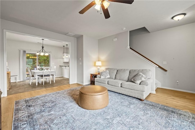 130 Whirlwind Way, Guyton, GA 31312 - living room with wood finished floors, a ceiling fan, a chandelier, and stairway