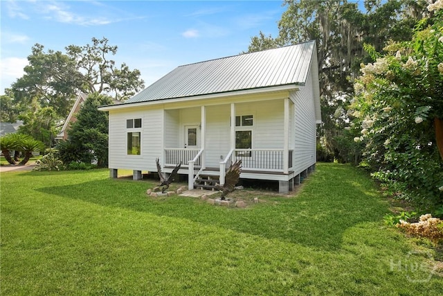 245 Youmans Rd, Midway, GA 31320 - view of front of property with a porch, a front yard, and a metal roof