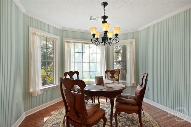 245 Youmans Rd, Midway, GA 31320 - dining room with crown molding, wood finished floors, a chandelier, a textured ceiling, and wallpapered walls