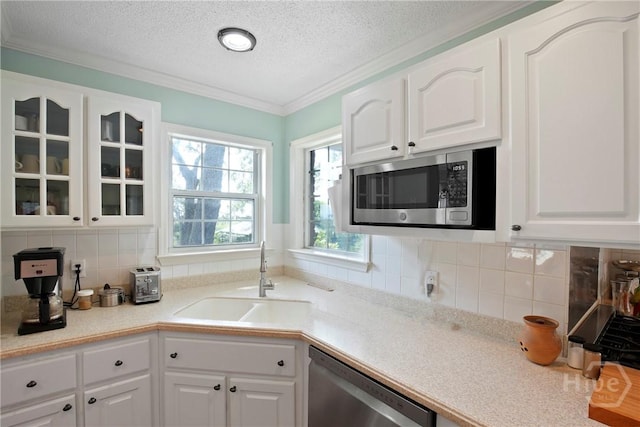 245 Youmans Rd, Midway, GA 31320 - kitchen featuring appliances with stainless steel finishes, glass insert cabinets, white cabinetry, a textured ceiling, and decorative backsplash