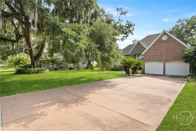 245 Youmans Rd, Midway, GA 31320 - view of front of home with concrete driveway, brick siding, a front lawn, and an attached garage