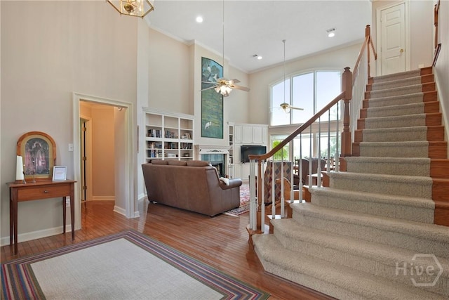 245 Youmans Rd, Midway, GA 31320 - stairway with a towering ceiling, ceiling fan, crown molding, wood finished floors, and a fireplace