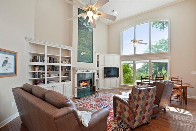 245 Youmans Rd, Midway, GA 31320 - living room with a high ceiling, a ceiling fan, a high end fireplace, wood finished floors, and crown molding