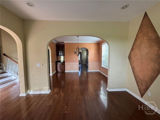 8 Fairgreen St, Savannah, GA 31407 - unfurnished dining area featuring dark wood-type flooring, arched walkways, a wainscoted wall, stairway, and crown molding