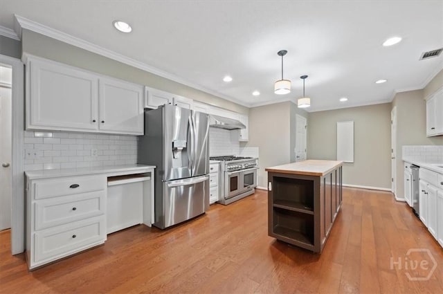 375 Hermitage Dr, Richmond Hill, GA 31324 - kitchen featuring stainless steel appliances, ornamental molding, tasteful backsplash, a kitchen island, and white cabinetry