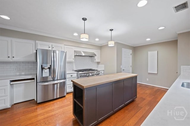 375 Hermitage Dr, Richmond Hill, GA 31324 - kitchen featuring appliances with stainless steel finishes, wooden counters, crown molding, white cabinets, and a center island