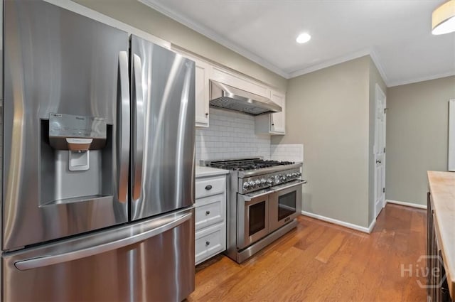 375 Hermitage Dr, Richmond Hill, GA 31324 - kitchen with stainless steel appliances, ventilation hood, white cabinetry, light countertops, and decorative backsplash