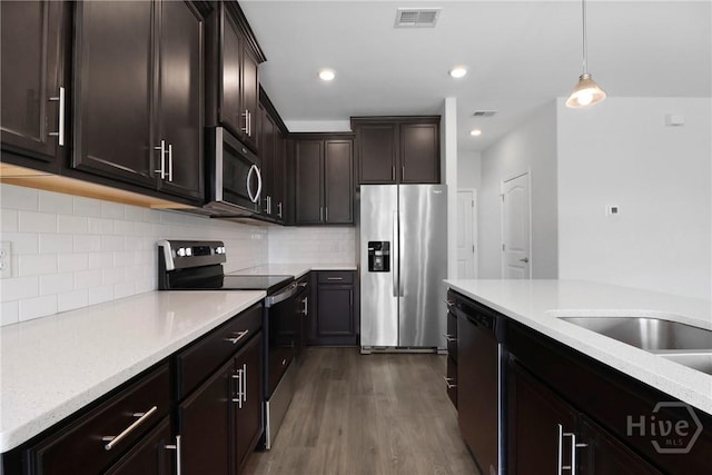 106 Brookline Dr, Savannah, GA 31407 - kitchen with stainless steel appliances, dark brown cabinetry, dark wood finished floors, hanging light fixtures, and decorative backsplash