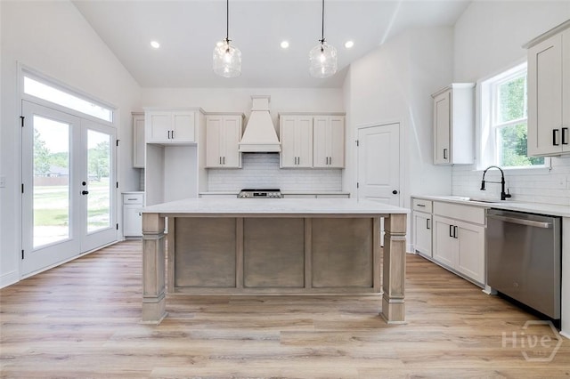 201 Dean Dr, Guyton, GA 31312 - kitchen featuring stainless steel dishwasher, custom range hood, vaulted ceiling, backsplash, and light countertops