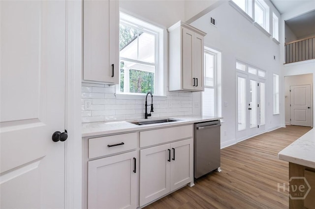 201 Dean Dr, Guyton, GA 31312 - kitchen featuring dishwasher, light wood-style flooring, backsplash, white cabinets, and a high ceiling