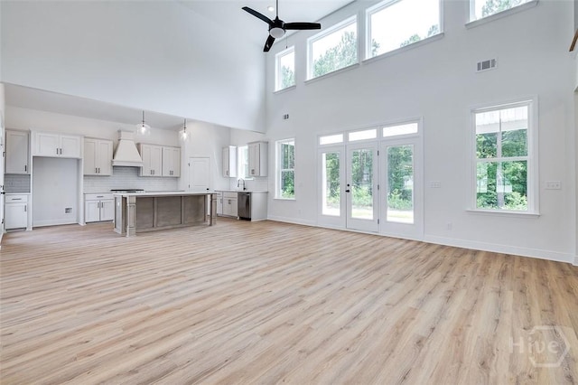 201 Dean Dr, Guyton, GA 31312 - unfurnished living room featuring ceiling fan, light wood-style floors, and a towering ceiling