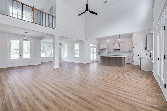 201 Dean Dr, Guyton, GA 31312 - unfurnished living room featuring a towering ceiling, light wood-type flooring, a ceiling fan, and french doors