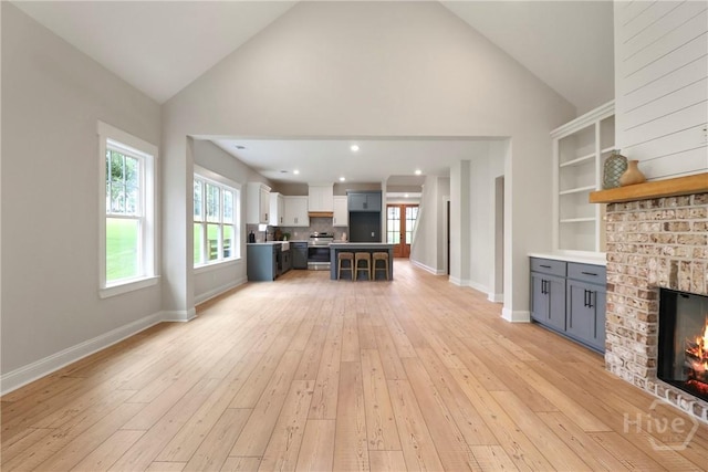 178 Cubbedge Dr, Rincon, GA 31326 - living room with a fireplace, high vaulted ceiling, light wood-style flooring, and plenty of natural light