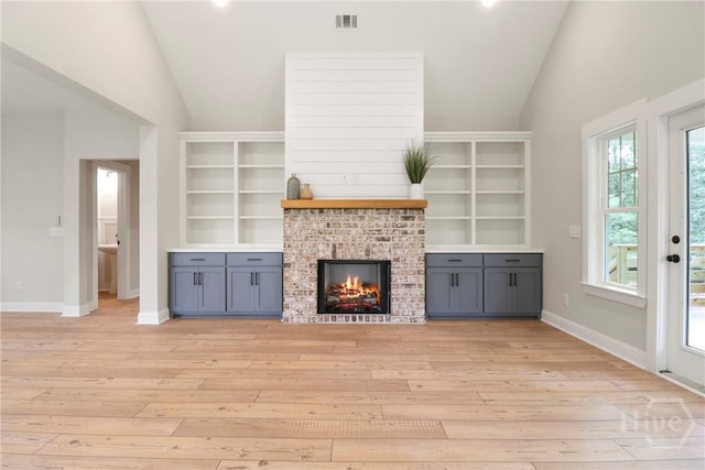 178 Cubbedge Dr, Rincon, GA 31326 - unfurnished living room featuring lofted ceiling, light wood-style flooring, and a brick fireplace