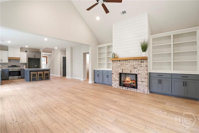 178 Cubbedge Dr, Rincon, GA 31326 - unfurnished living room featuring ceiling fan, a fireplace, light wood-style floors, high vaulted ceiling, and recessed lighting