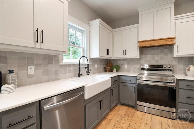 178 Cubbedge Dr, Rincon, GA 31326 - kitchen featuring appliances with stainless steel finishes, gray cabinetry, custom range hood, light countertops, and tasteful backsplash