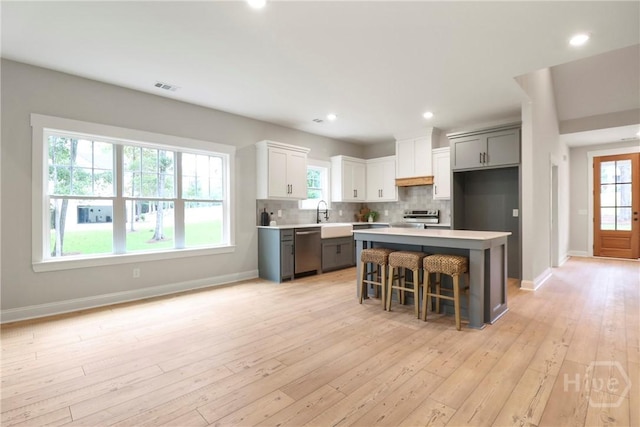 178 Cubbedge Dr, Rincon, GA 31326 - kitchen with dishwasher, stove, light wood-type flooring, light countertops, and decorative backsplash