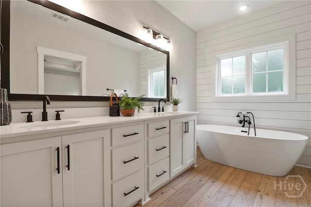 178 Cubbedge Dr, Rincon, GA 31326 - full bath featuring double vanity, wood-type flooring, a freestanding tub, and wood walls